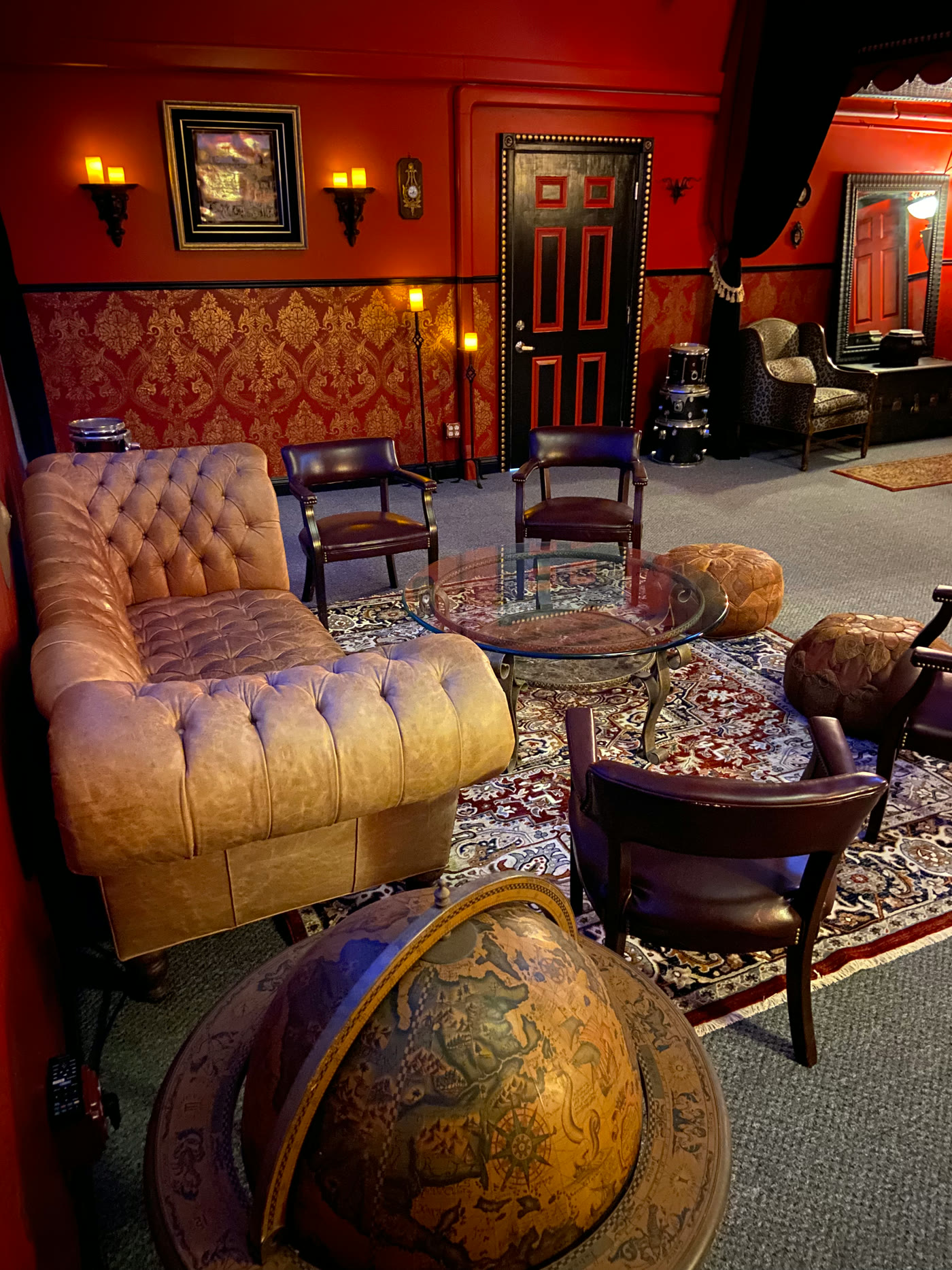 Sofa, chairs and a glass coffee table in Fuzz Box’s red-walled creative lounge